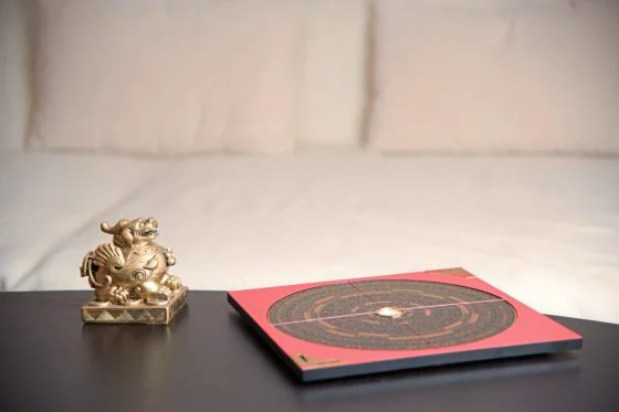 An asian symbol and a Feng Shui compass on a table