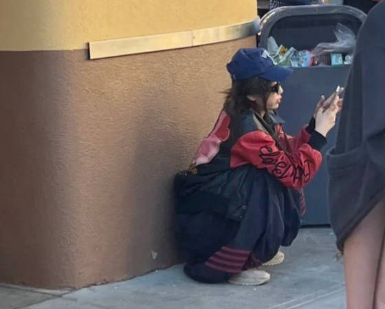 虞书欣美式复古辣妹装扮 蹲垃圾桶旁滑手机全被拍