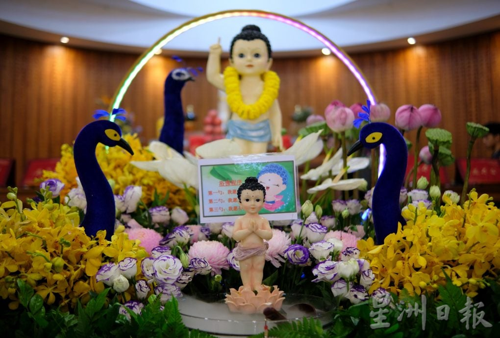 (22/6见报)星角摄(未签发):卫塞节花香满寺,心敬佛恩。