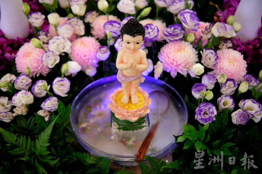 (22/6见报)星角摄(未签发):卫塞节花香满寺,心敬佛恩。