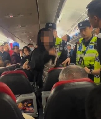 中国女乘客机上失控被带走 手写保证书网上疯传