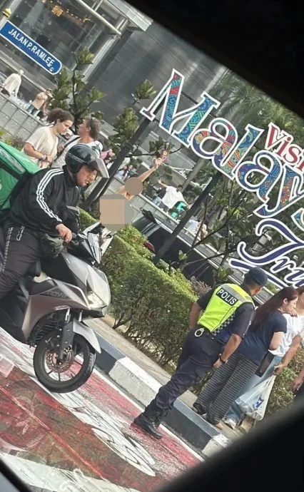 女子KLCC外高举护照引围观 身有淤伤坚称只见使馆人员