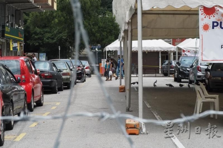 难民和移工的身影三三两两，或到杂货店买东西，或领了物资匆匆上楼。