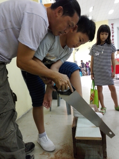 薛应杰在小木凳亲子工坊里让孩子决定木凳子该多高多长,大人则协助锯木、钉钉子的操作。 薛应杰在小木凳亲子工坊里让孩子决定木凳子该多高多长,大人则协助锯木、钉钉子的操作。