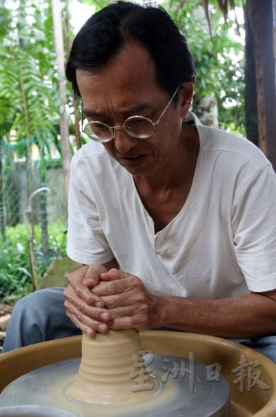 黄纬良正在拉坯，塑造出陶土的形状。