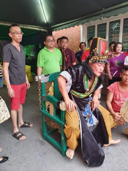 邱宜哲(绿衣)喜欢到神庙帮忙是因为,他从庙里遇到和听到的人生百态中,学习到不少人生道理。(受访者提供)