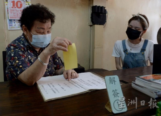 蓝姐（左）在七宫仙女庙服务已接近20年，也负责给信徒解签。