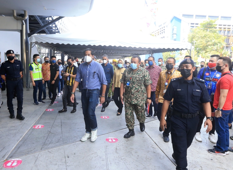 凯里（左一）巡视武吉加里尔亚通体育馆疫苗接种中心的准备工作。

